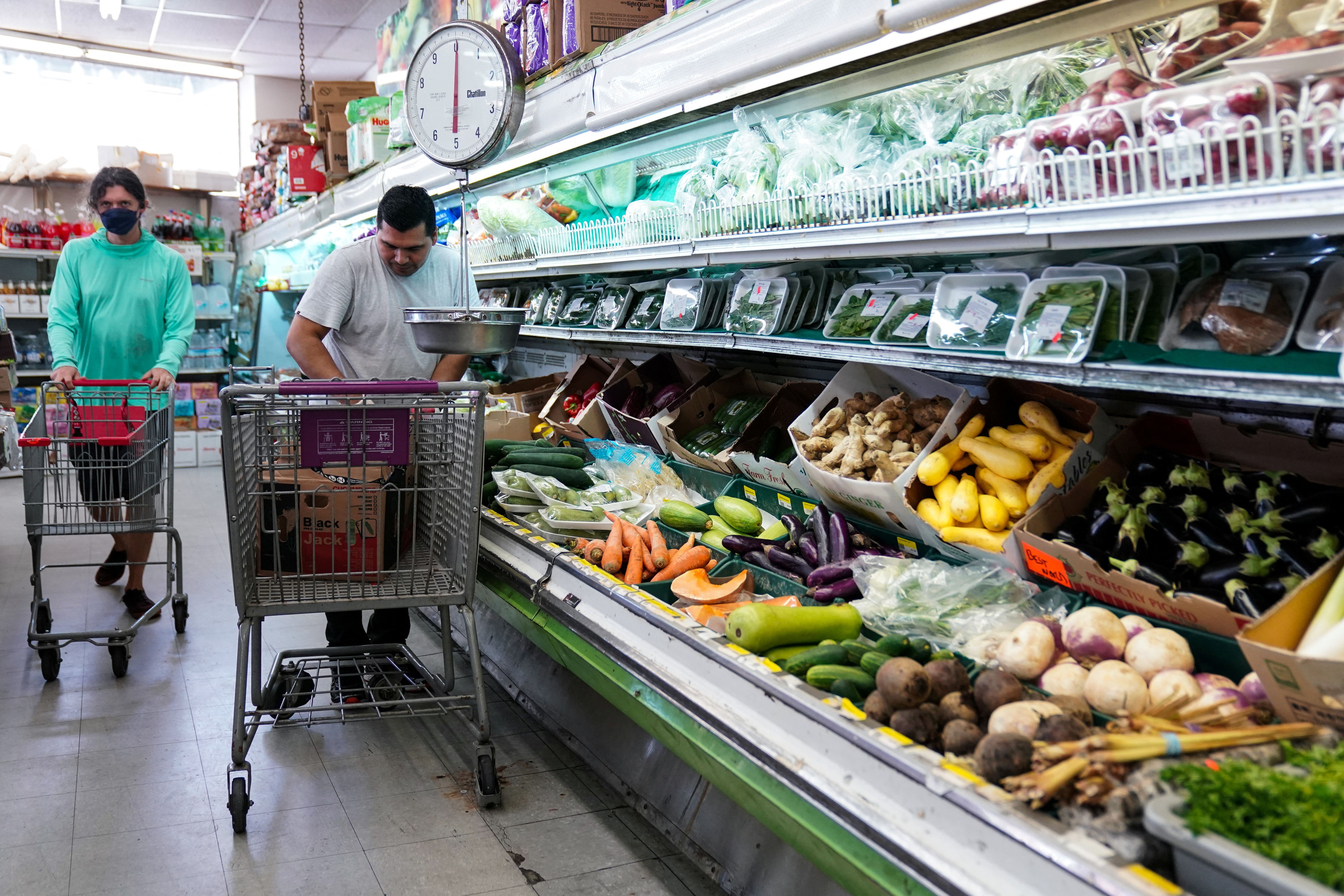 A man arranges produce at Best World Supermarket in Washington DC.