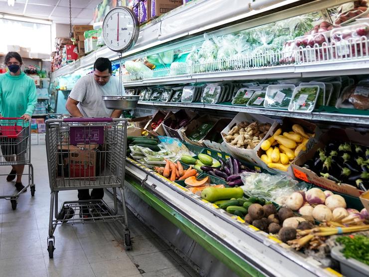 A man arranges produce at Best World Supermarket in Washington DC.