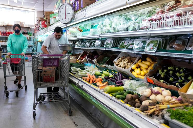 A man arranges produce at Best World Supermarket in Washington DC.
