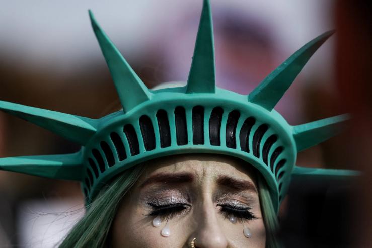 A protester dressed like a crying Statue of Liberty