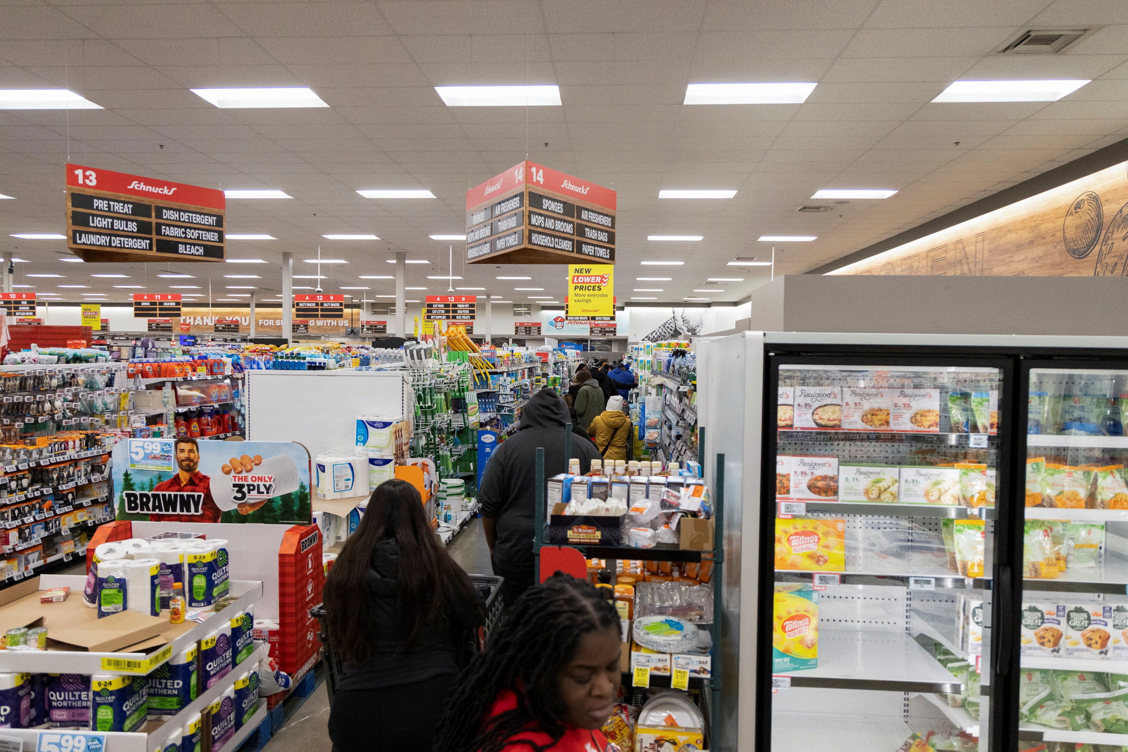 Shoppers wait in long checkout lines as residents stock up on food and household supplies.