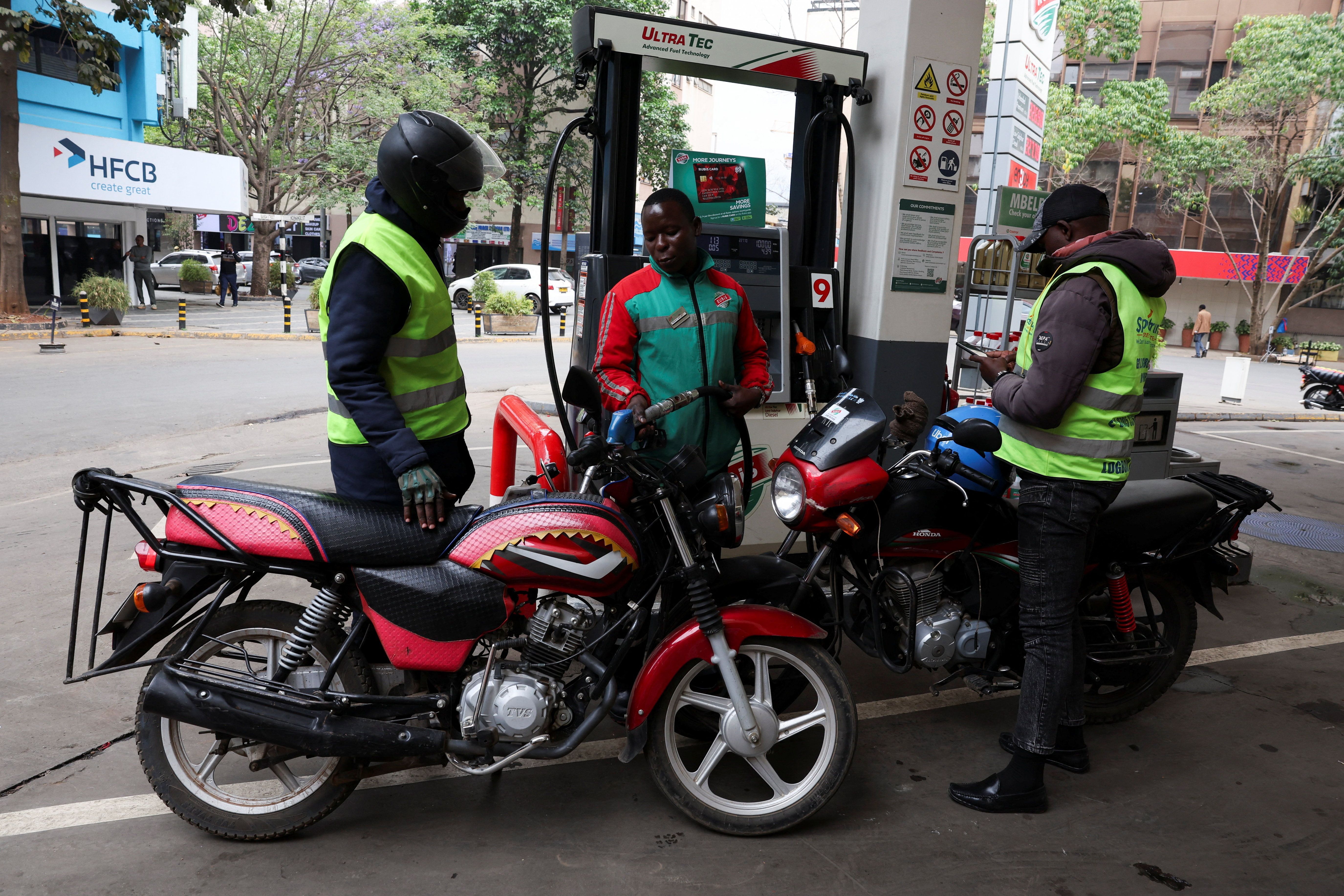 A pump attendant fuels a motorcycle in Nairobi.