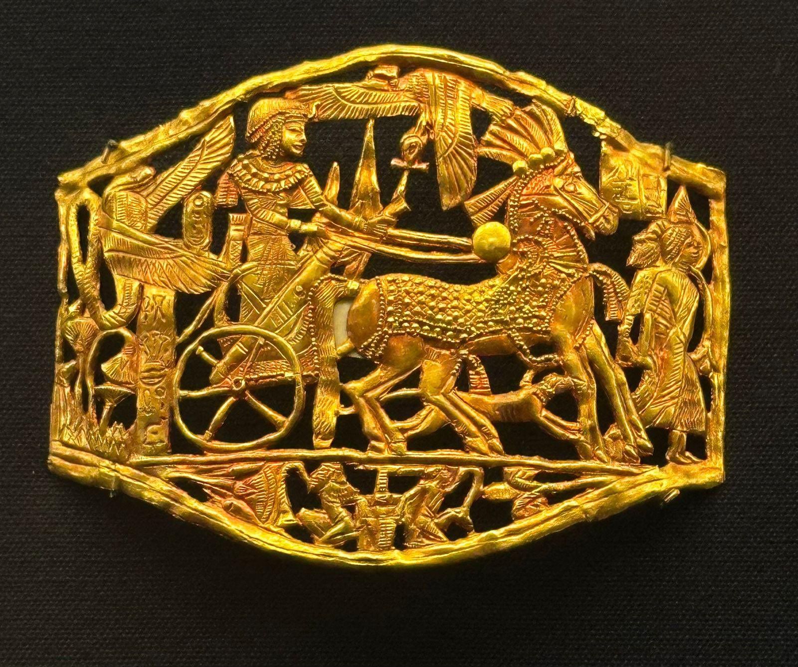 A gold buckle recovered from King Tut’s tomb, depicting a pharoah riding in a chariot.