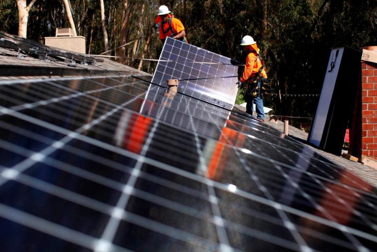 Solar installers from Baker Electric place solar panels on the roof of a residential home in Scripps Ranch, San Diego, California.