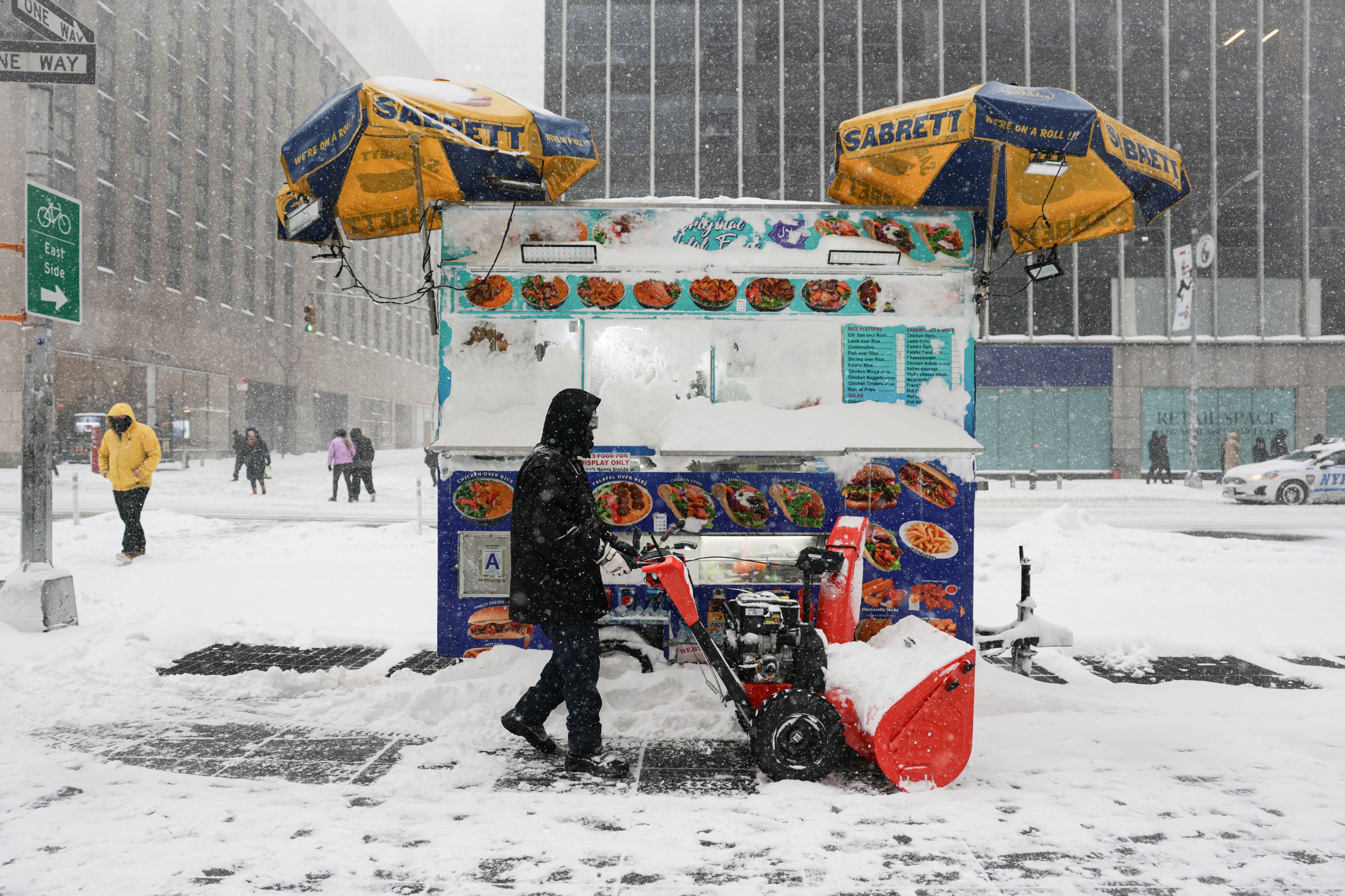 A worker clears snow from the street near Times Square