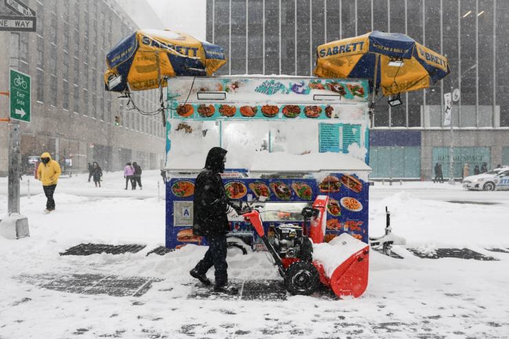 A worker clears snow from the street near Times Square
