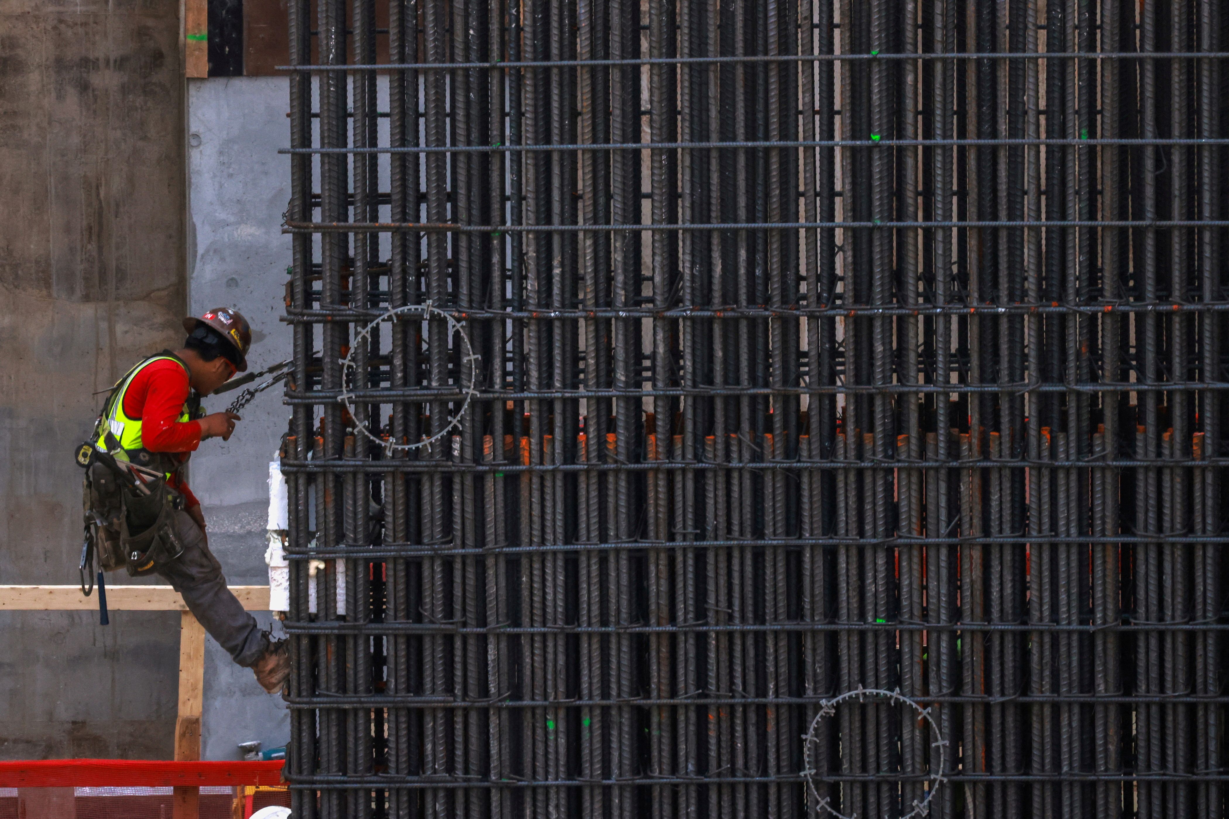 Workers install steel rods at a construction site in Miami.