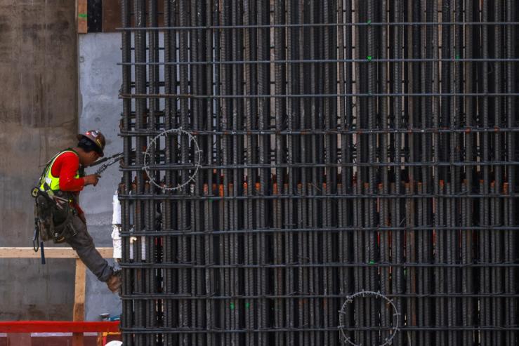 Workers install steel rods at a construction site in Miami.