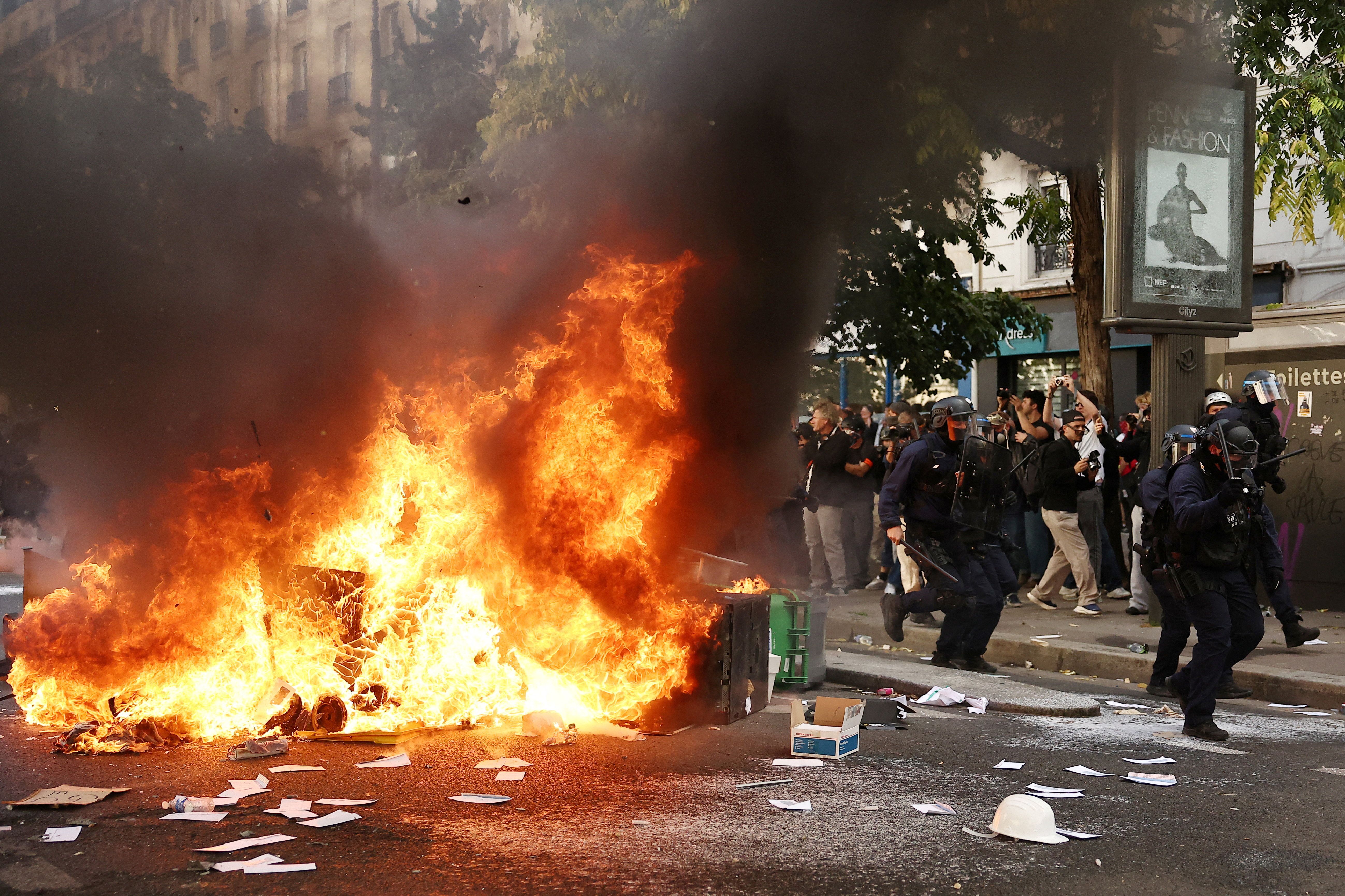French CRS riot police run past garbage bins and object set on fire amid clashes with protesters during a demonstration by high school and university students, supported by teachers’ union and school parents, in Paris as part of a nationwide day of protests and blockades, voicing anger over overcrowded classrooms, teacher shortages and dilapidated school buildings, which students blame on years of underinvestment, France