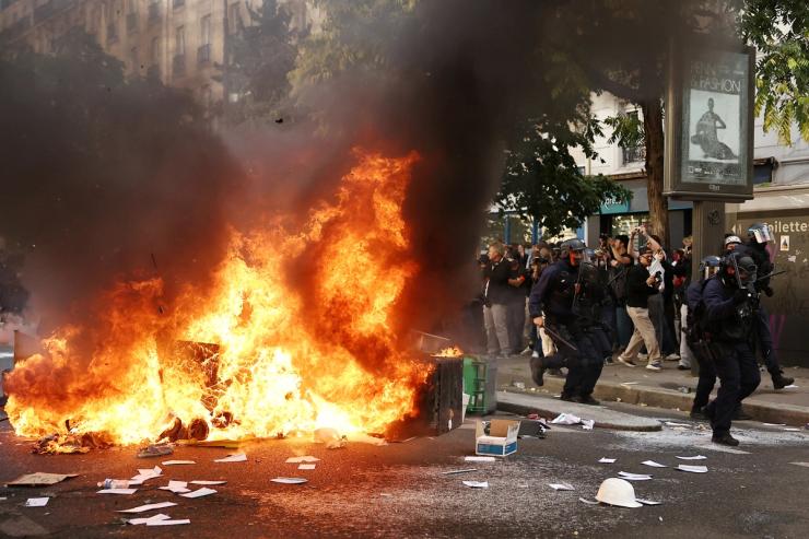 French CRS riot police run past garbage bins and object set on fire amid clashes with protesters during a demonstration by high school and university students, supported by teachers’ union and school parents, in Paris as part of a nationwide day of protests and blockades, voicing anger over overcrowded classrooms, teacher shortages and dilapidated school buildings, which students blame on years of underinvestment, France
