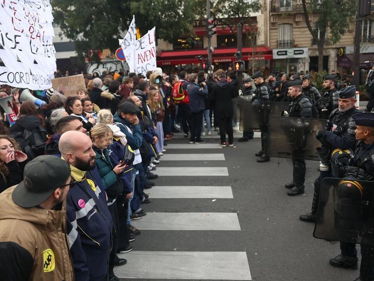 Police officers block the street during a protest organized by student collectives and trade unions in Paris, France.