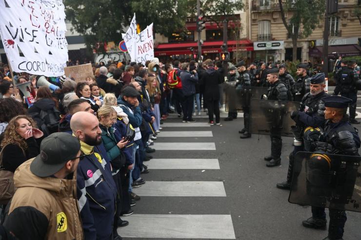 Police officers block the street during a protest organized by student collectives and trade unions in Paris, France.