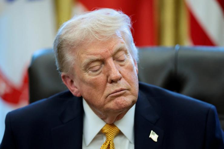 U.S. President Donald Trump listens to a question from a reporter during an event to sign an executive order creating an anti‑fraud task force headed by U.S. Vice President JD Vance in the Oval Office