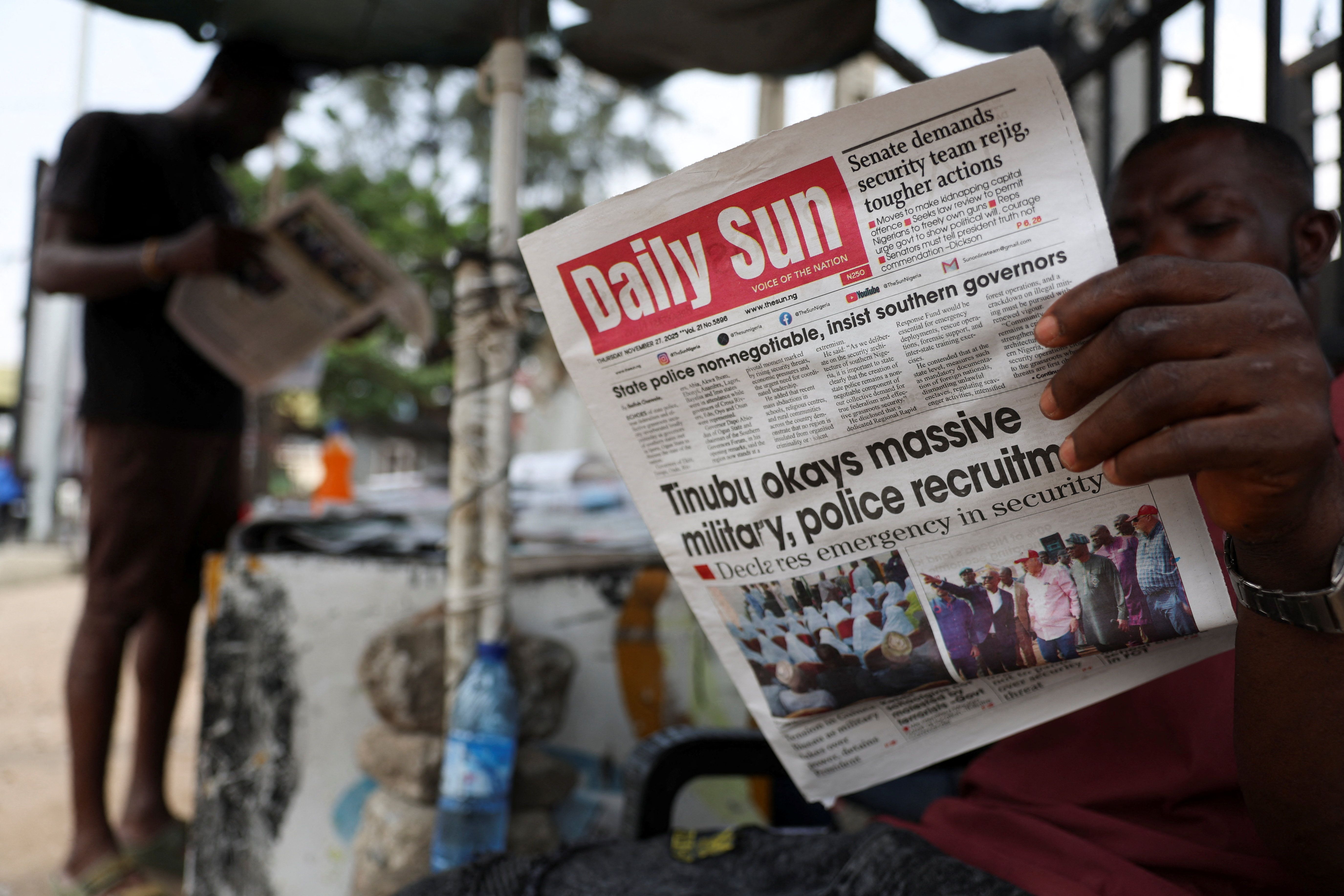 People read newspapers at a roadside newspaper stand in Ikoyi Lagos, Nigeria.