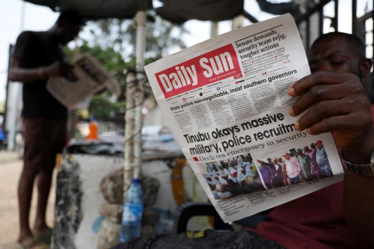 People read newspapers at a roadside newspaper stand in Ikoyi Lagos, Nigeria.