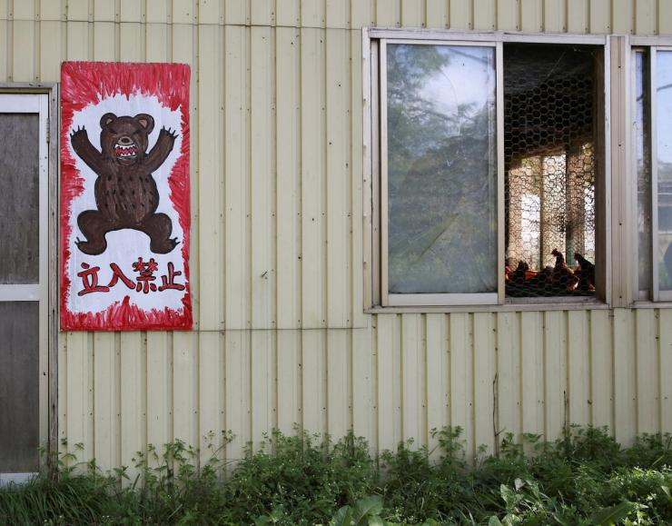 A sign with a bear reading “Do not enter” in Japanese.