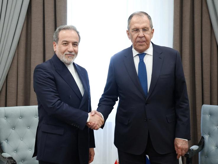 Russian Foreign Minister Sergei Lavrov shakes hands with Iranian Foreign Minister Abbas Araqchi during their talks on the sidelines of the Shanghai Cooperation Organisation
