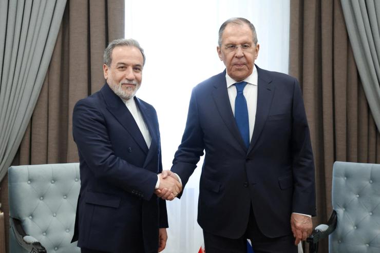 Russian Foreign Minister Sergei Lavrov shakes hands with Iranian Foreign Minister Abbas Araqchi during their talks on the sidelines of the Shanghai Cooperation Organisation
