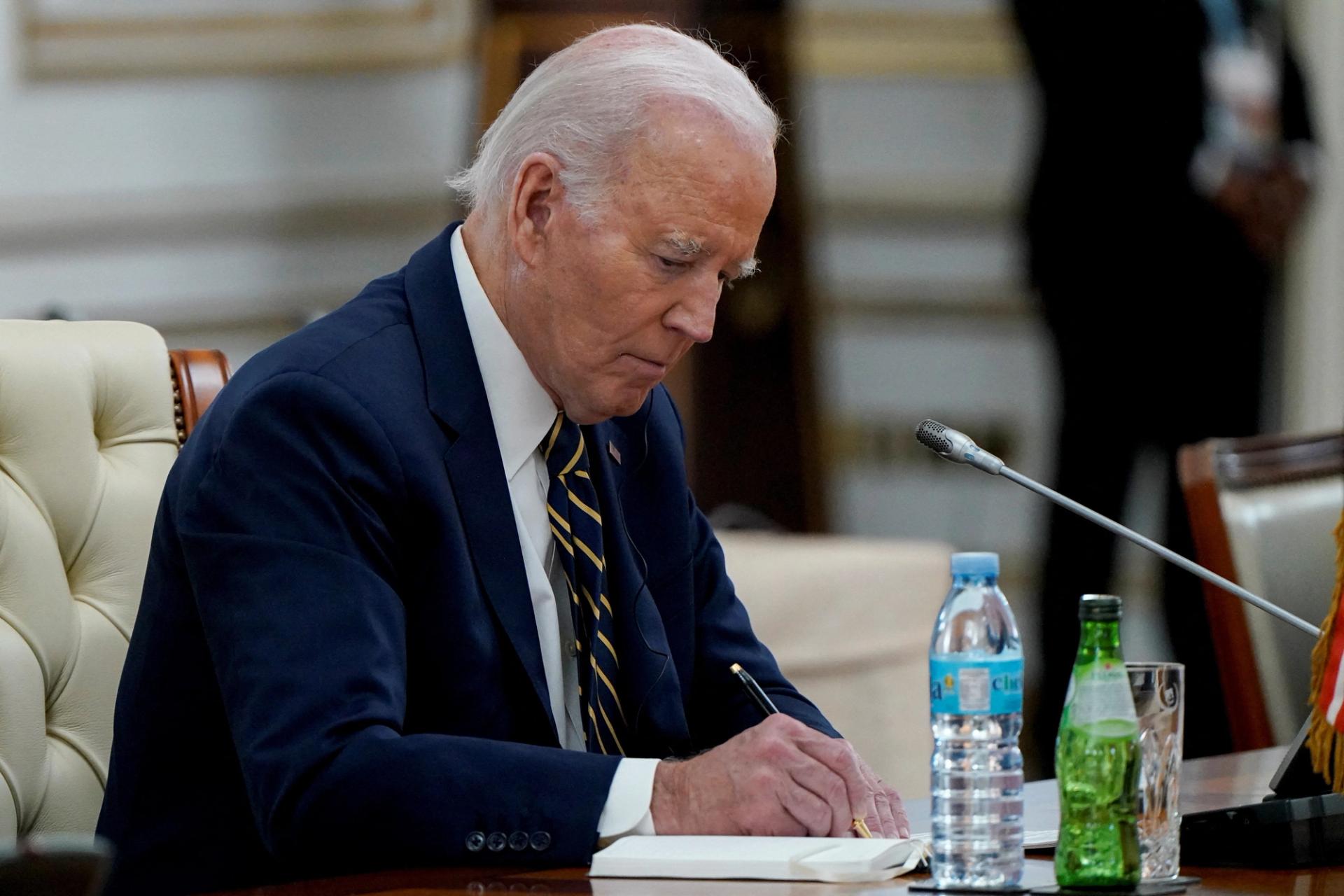 Joe Biden, wearing a dark suit and striped tie, in Angola in December