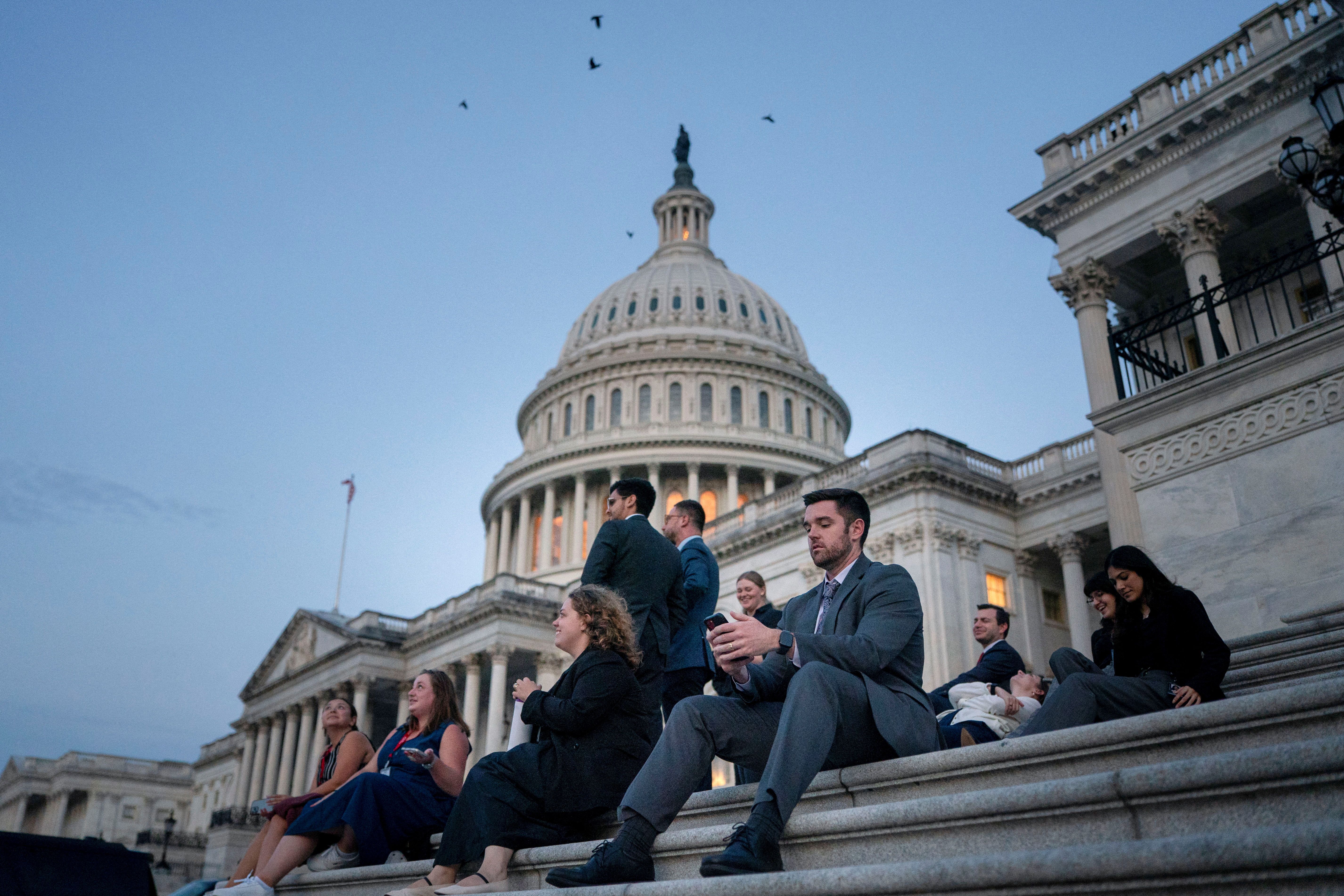 Senate staffers rest on the Capitol steps during debate on the bill