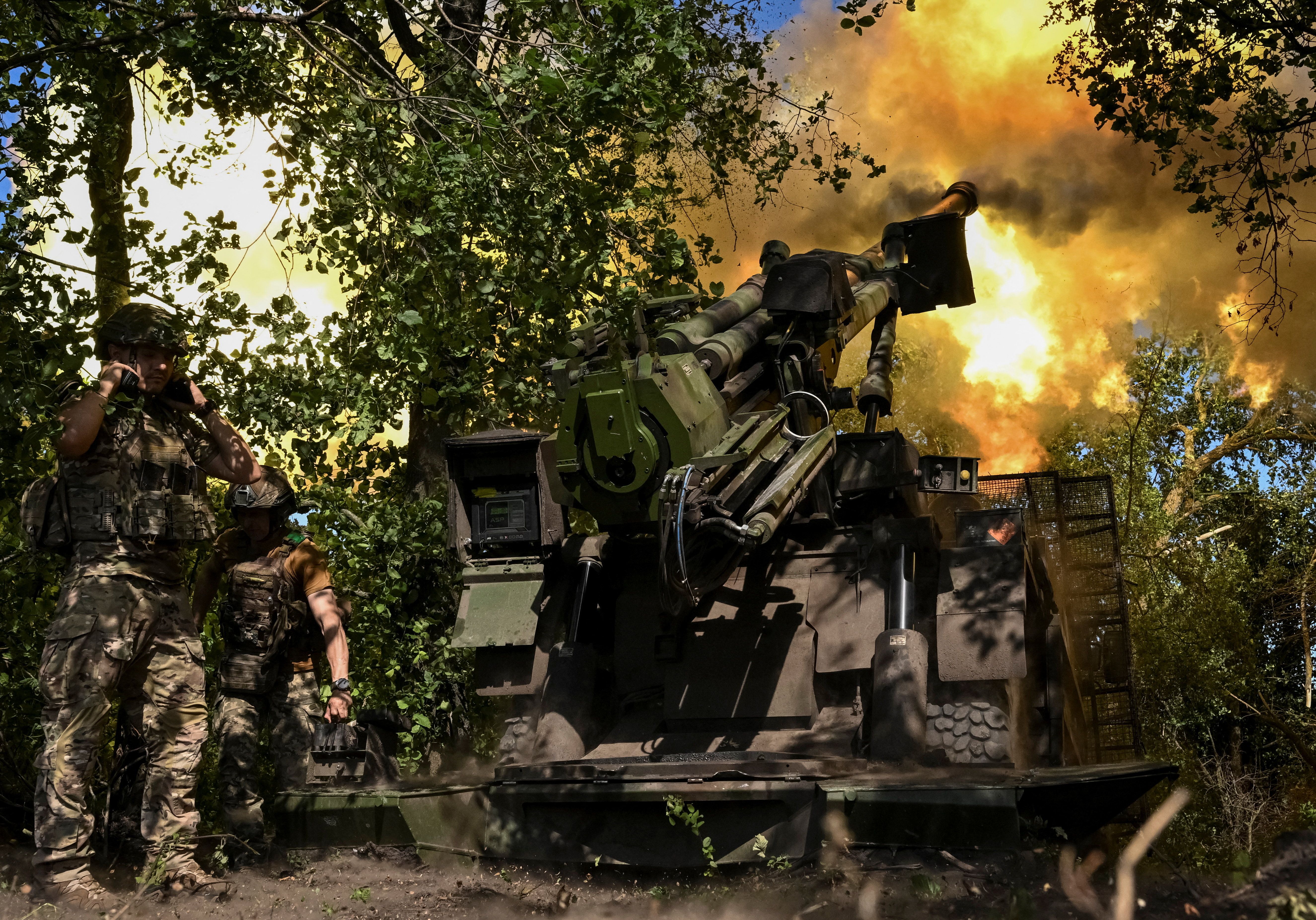 Ukrainian soldiers fire a howitzer