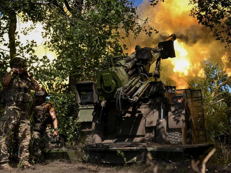 Ukrainian soldiers fire a howitzer