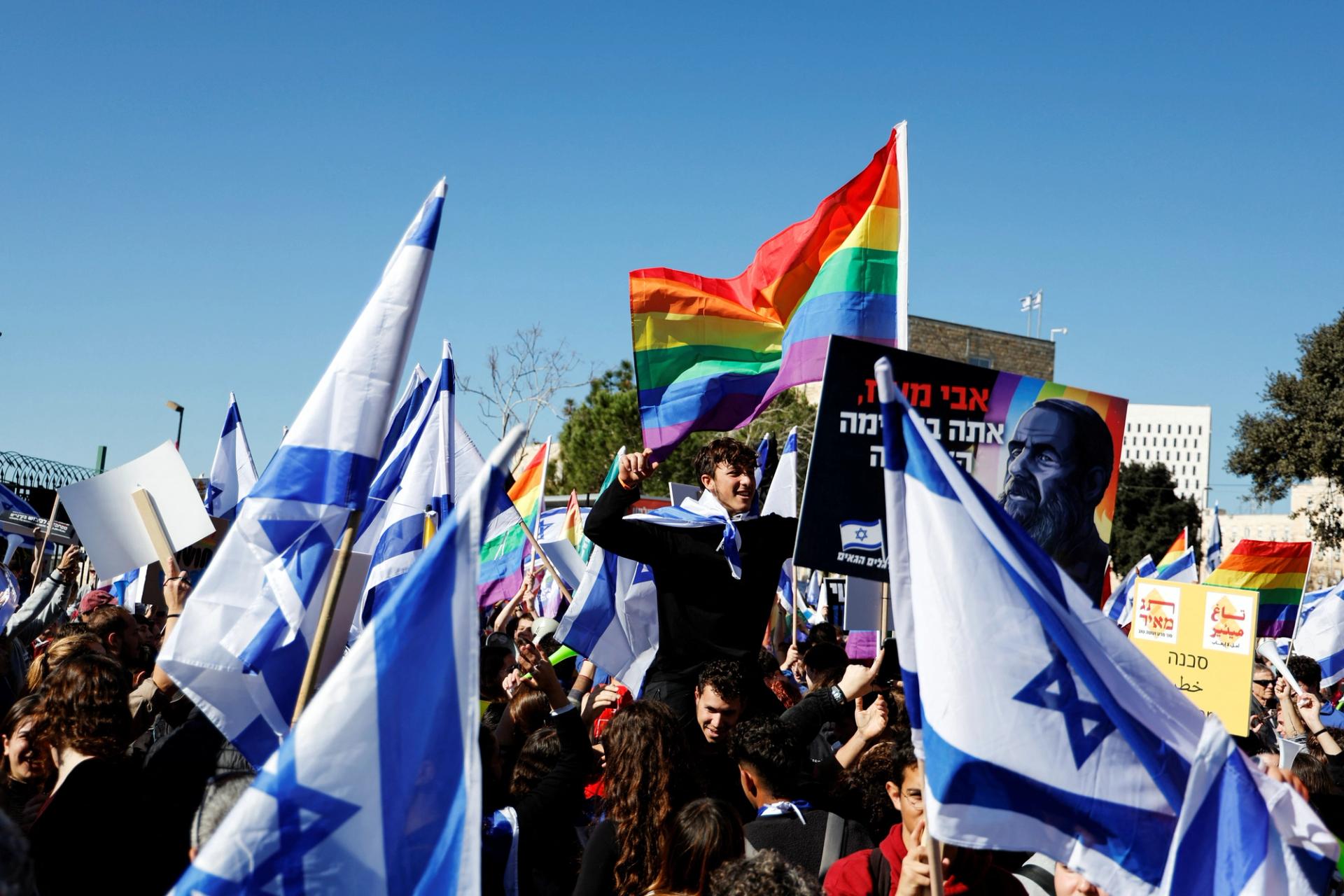 Israelis hold flags and shout slogans at a protest outside the Knesset in Jerusalem
