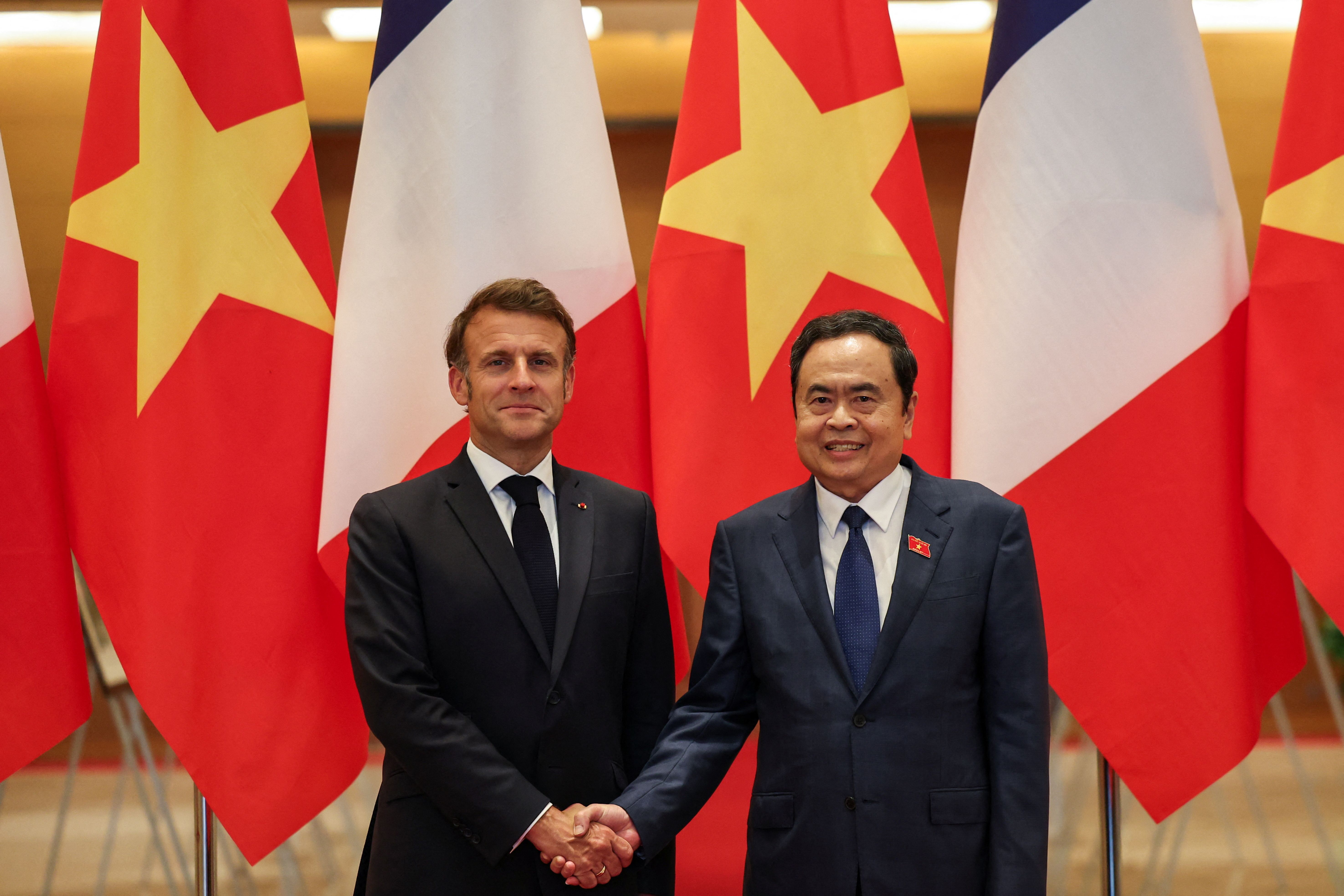 French President Emmanuel Macron and Chairman of Vietnam’s National Assembly Tran Thanh Man shake hands at the National Assembly.
