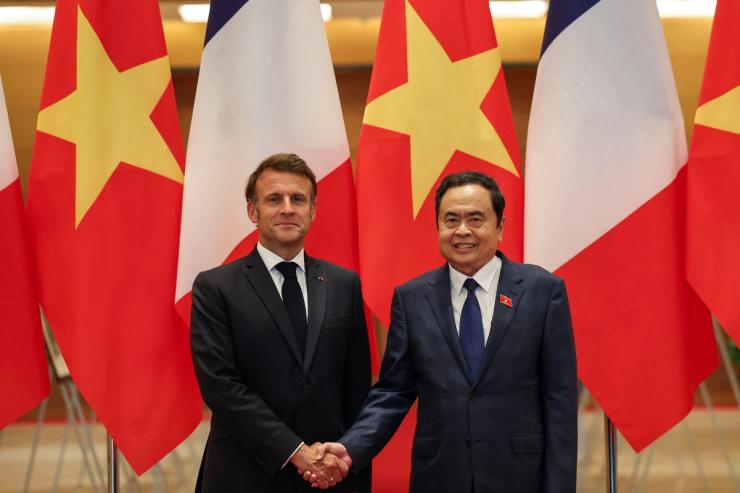 French President Emmanuel Macron and Chairman of Vietnam’s National Assembly Tran Thanh Man shake hands at the National Assembly.