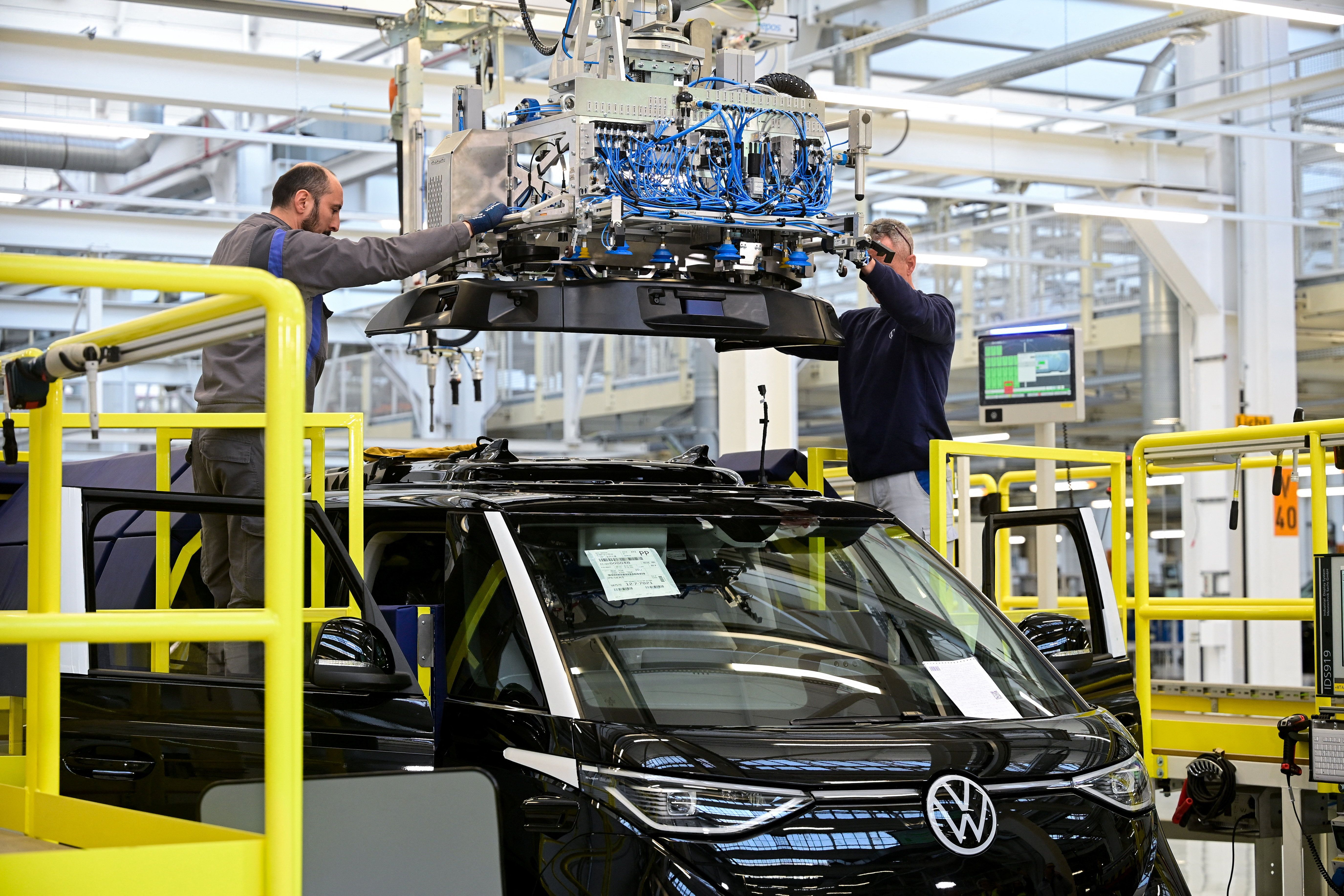 Staff members install a sensor unit on a Volkswagen Id. Buzz AD during a media tour at Volkswagen Commercial Vehicles (Volkswagen Nutzfahrzeuge) in Hanover, Germany.